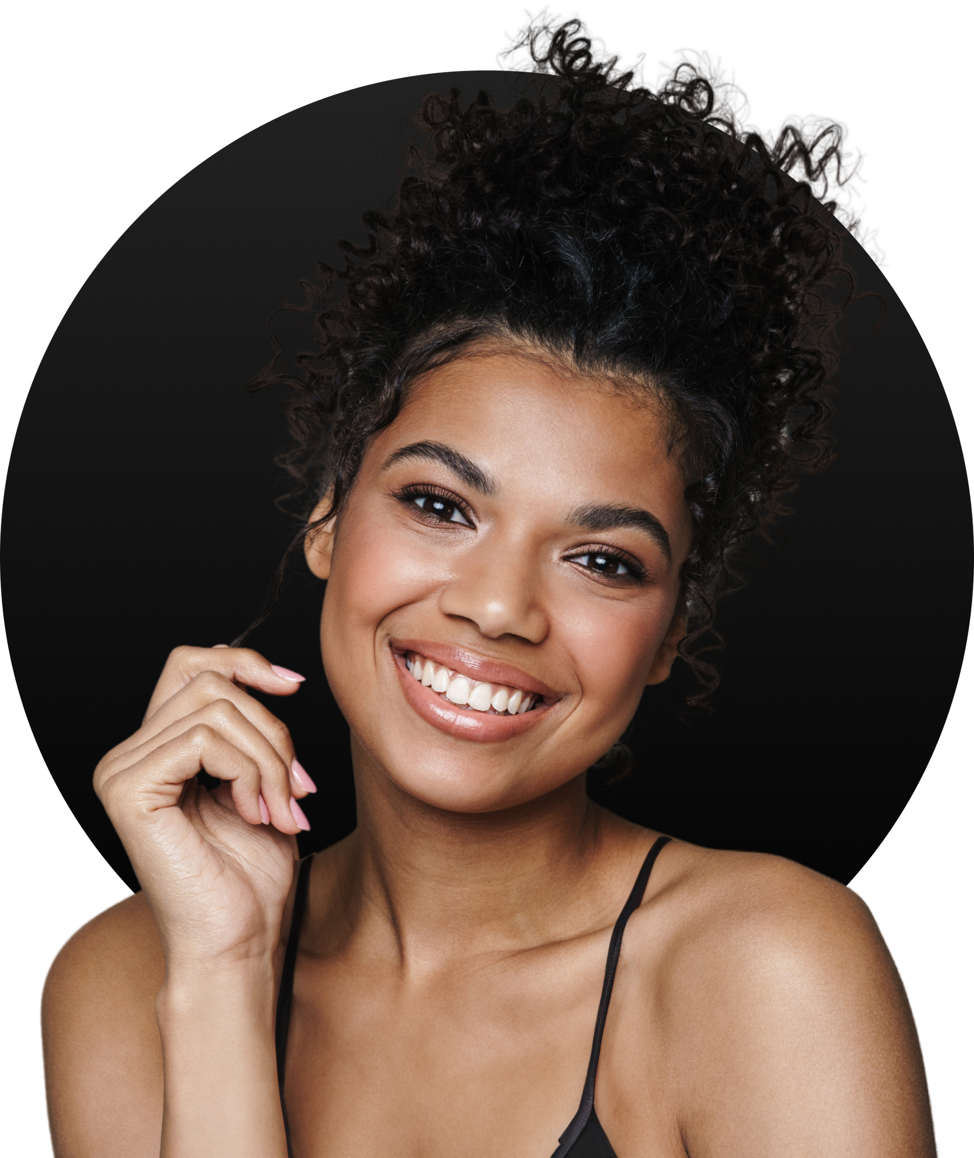 A woman with curly hair is smiling in front of a black circle.