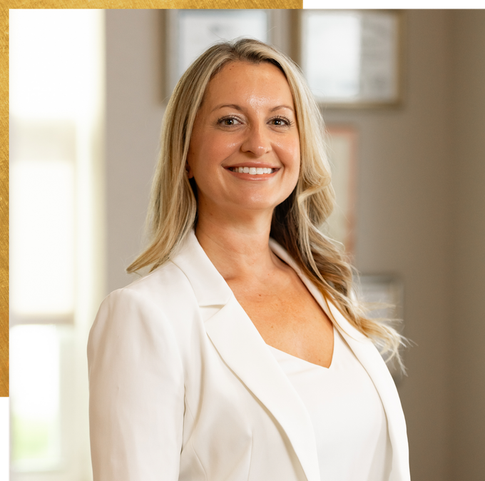 Dr. Amanda Sindledecker in a white jacket and white shirt is smiling for the camera