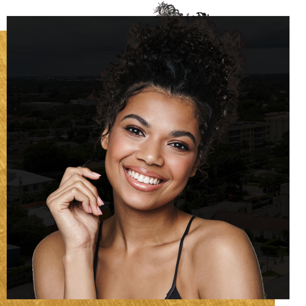 A woman with curly hair is smiling for the camera