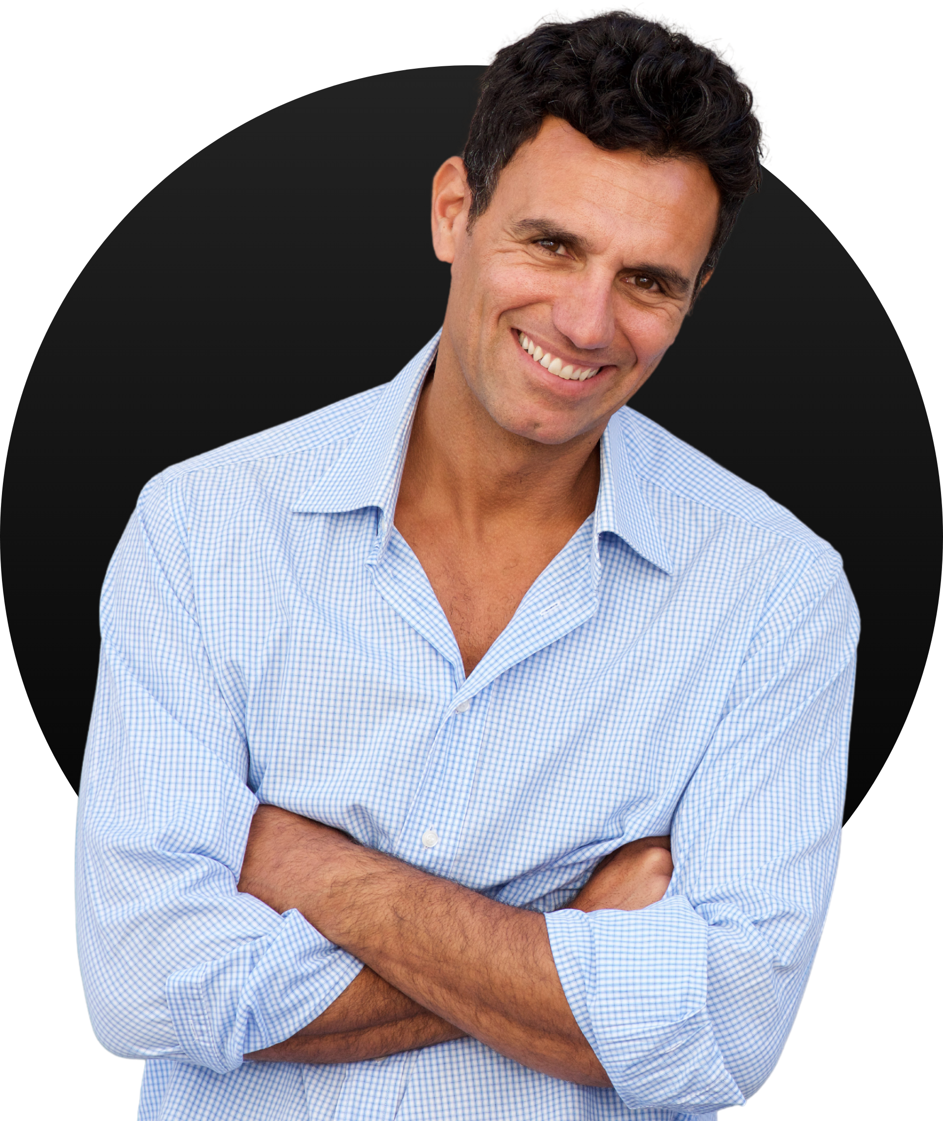 A man in a blue shirt is smiling with his arms crossed