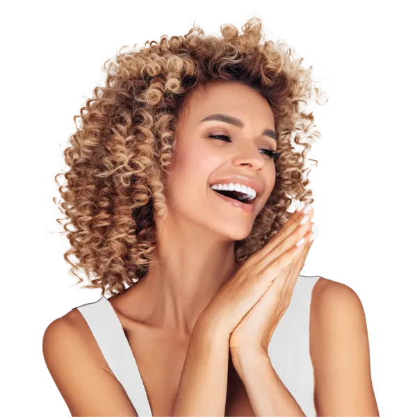 A woman with curly hair is smiling and covering her face with her hands