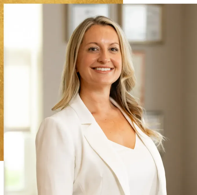 Dr. Amanda Sindledecker in a white jacket and white shirt is smiling for the camera