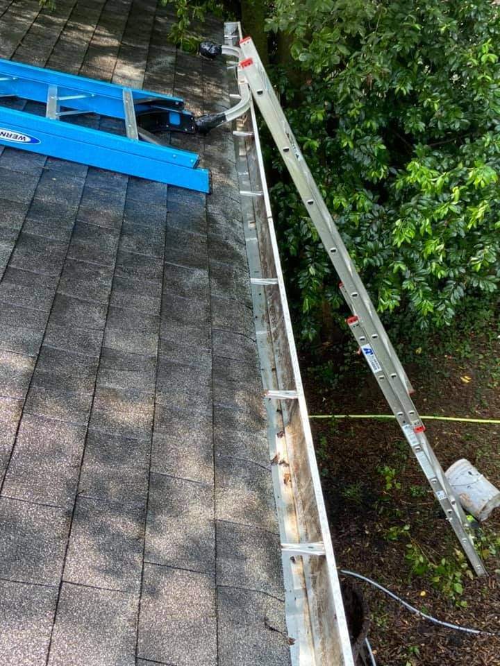 Ladders and tools in use for professional gutter cleaning on a shingled roof in Lebanon, TN.