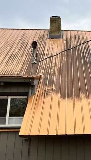 A close up of a roof with a chimney on top of it.