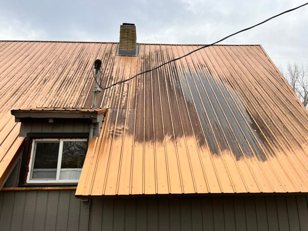 The roof of a house is being painted yellow.