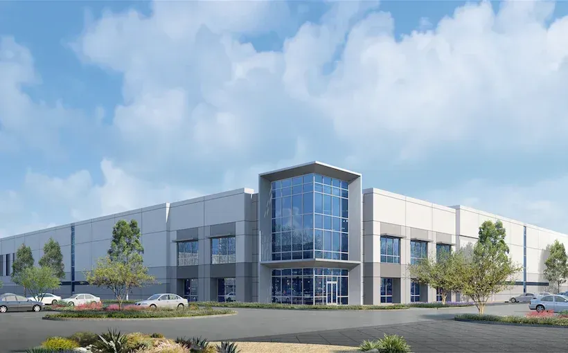 Exterior of a dental office with a gray and orange facade, blue sky, and a curved driveway.