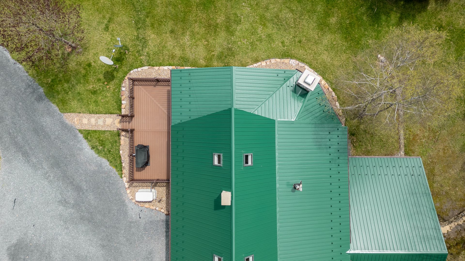 An aerial view of a house with a green roof and a deck.