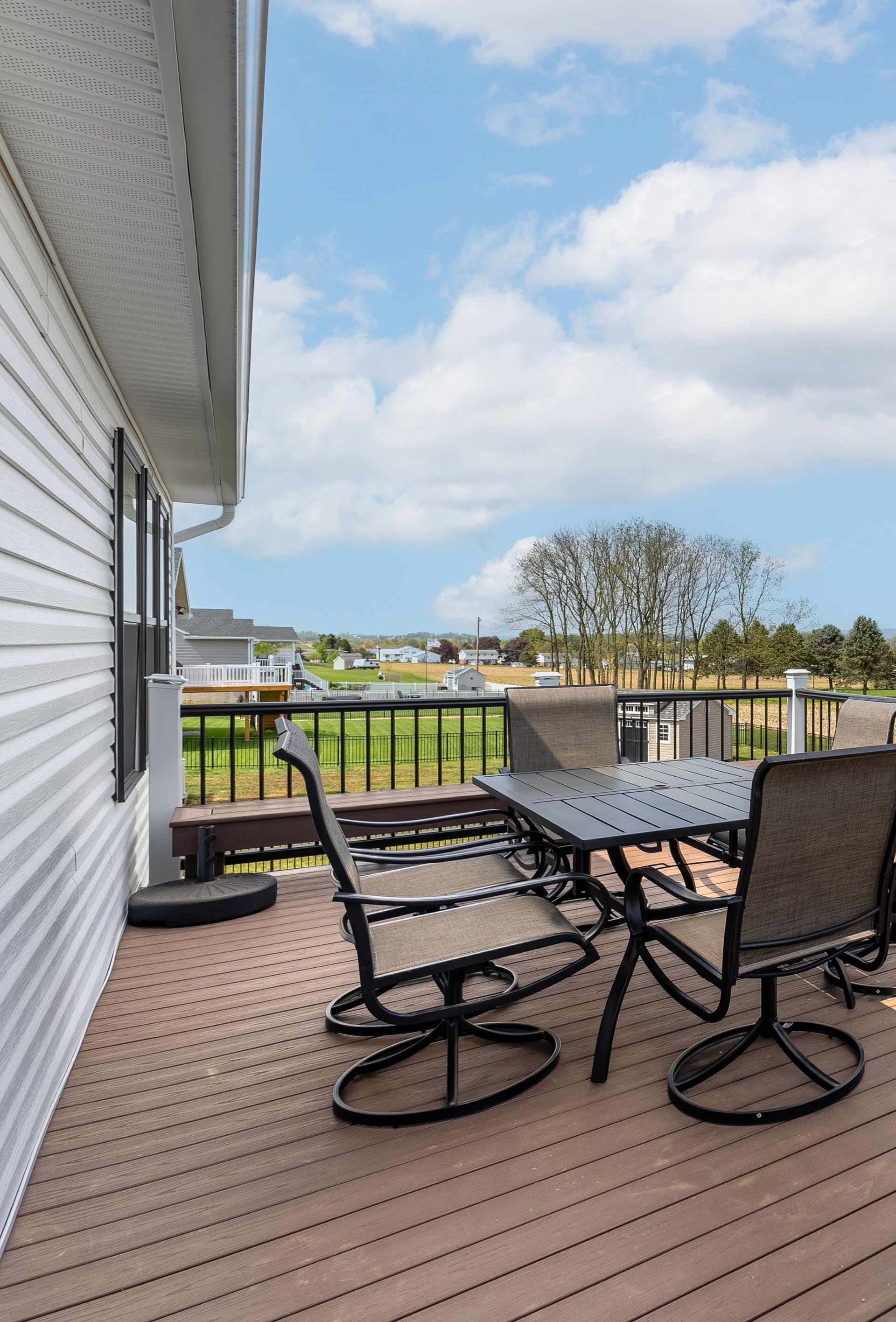 There is a deck with a table and chairs on it.
