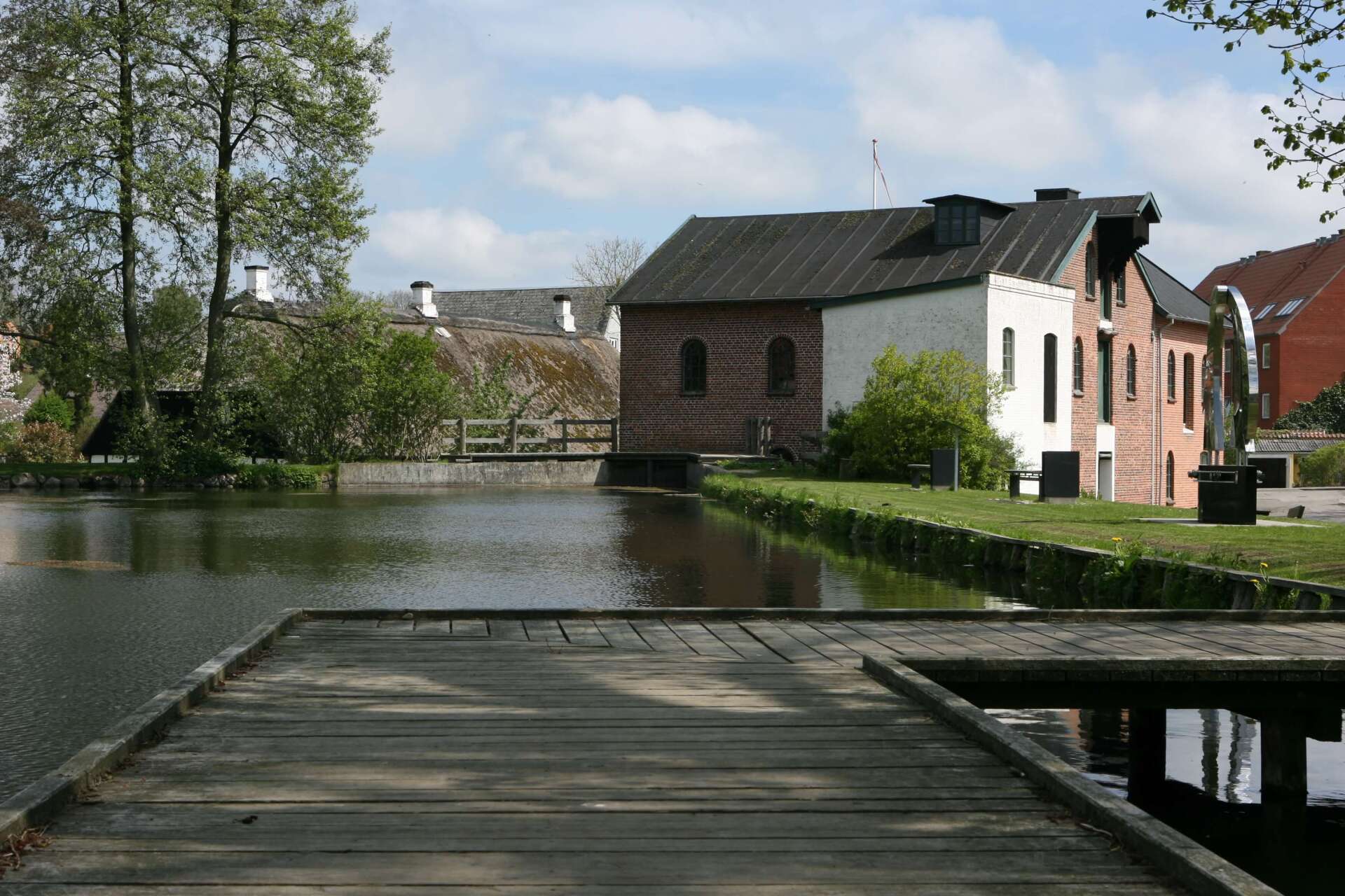 En trædok, der fører til en bygning ved siden af ​​en vandmasse