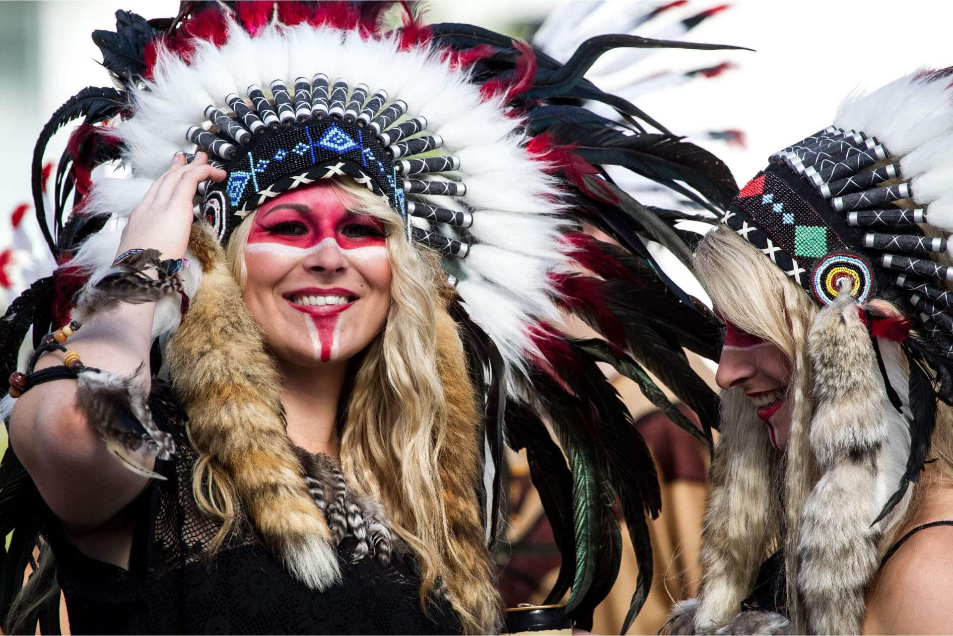 To kvinder klædt i indianske kostumer smiler til kameraet