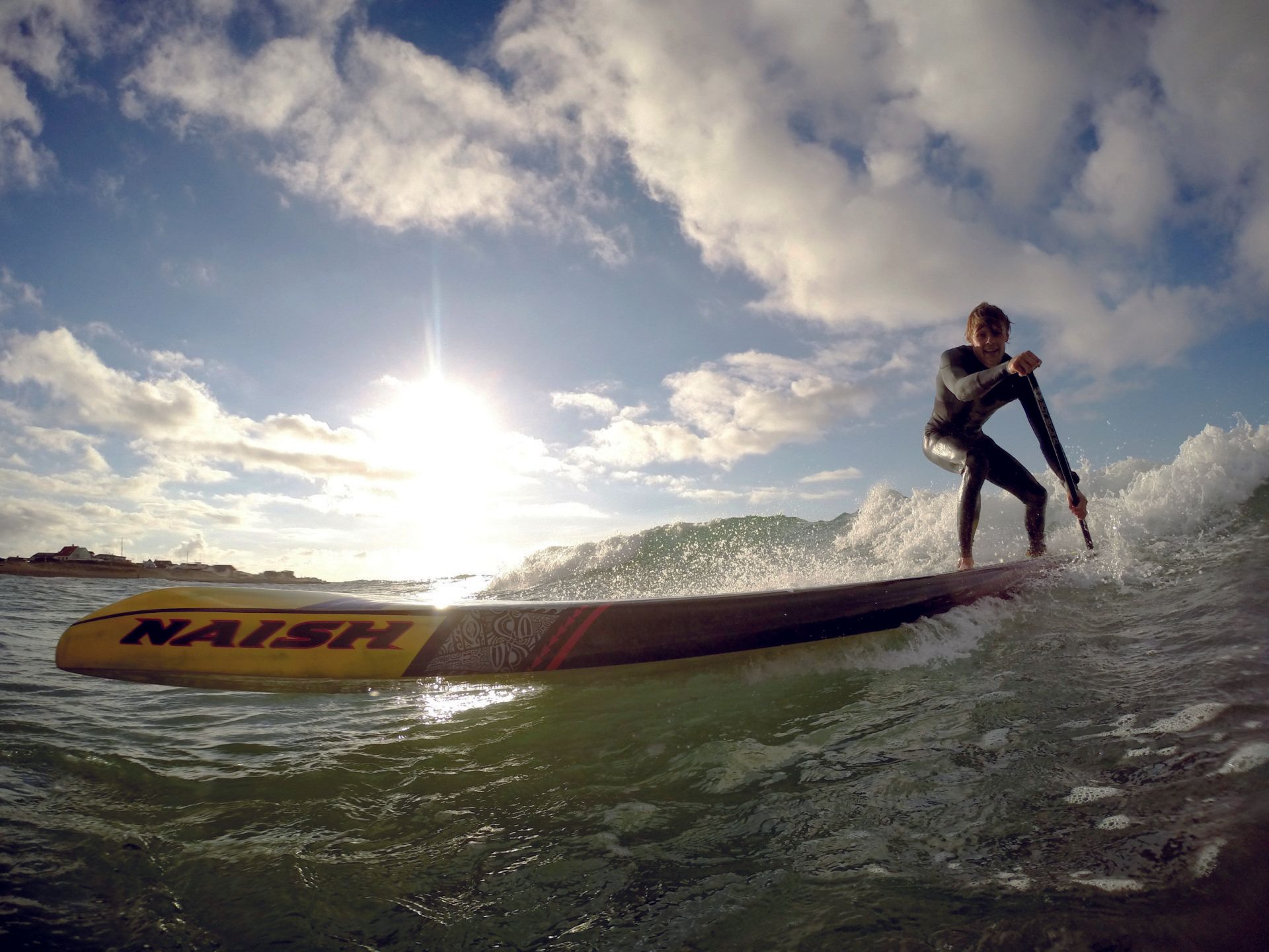 En mand rider på en bølge på et surfbræt i havet.