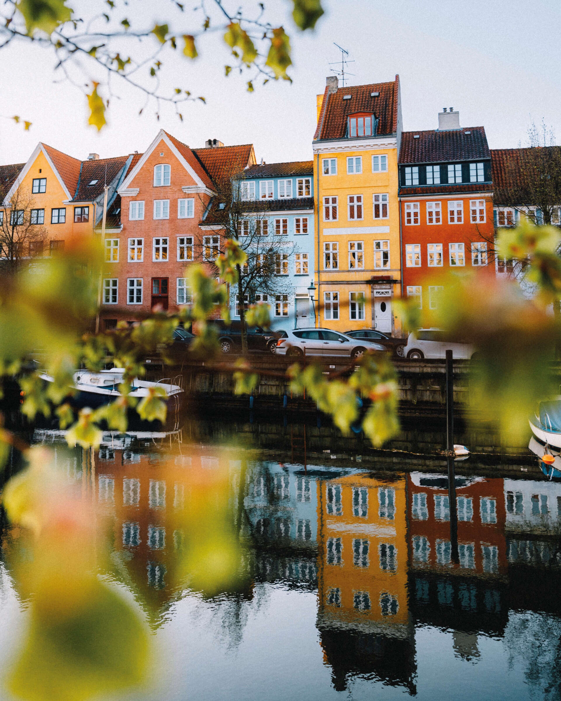 En række bygninger reflekteres i en vandmasse
