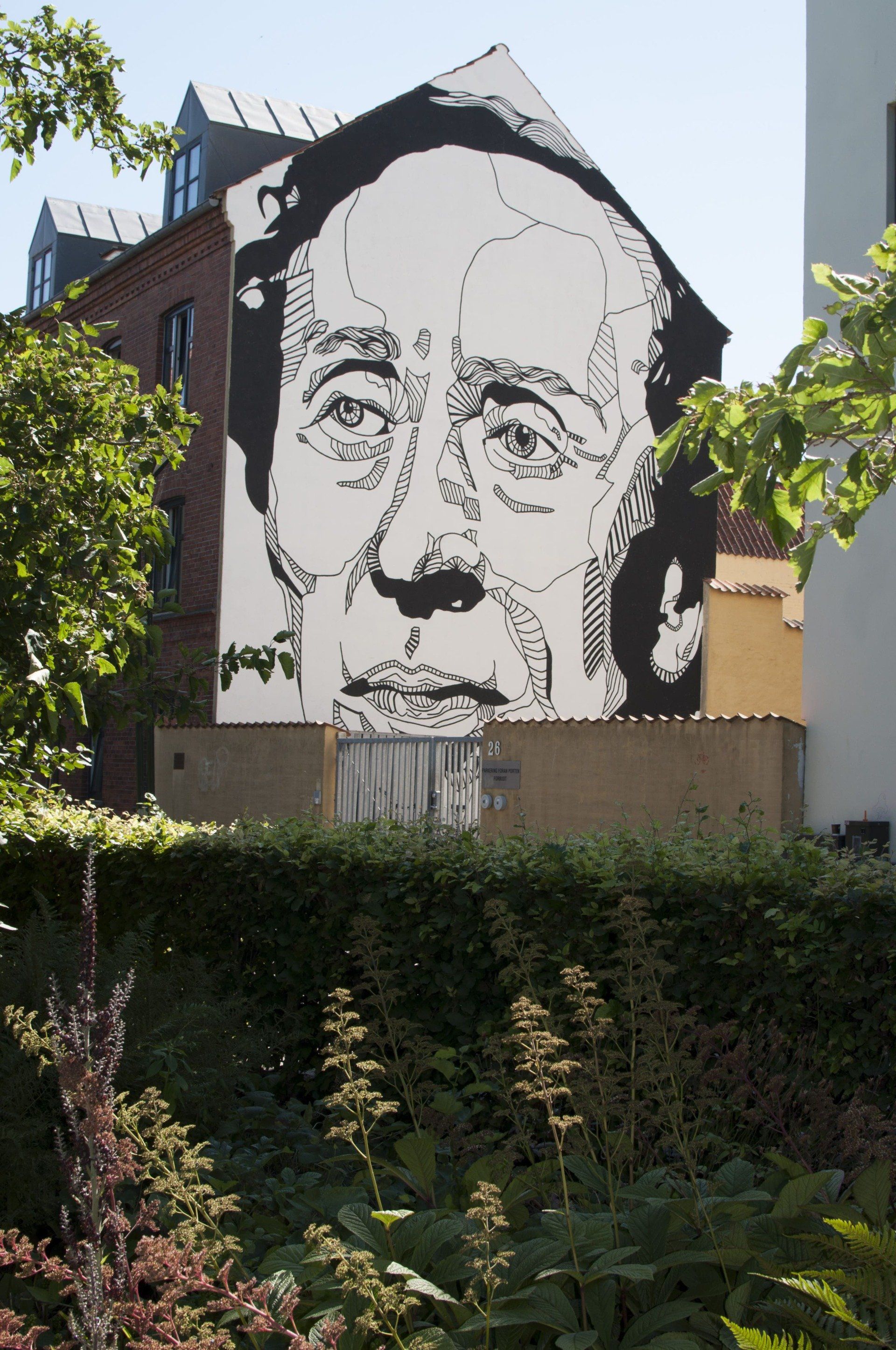 En sort/hvid tegning af en mands ansigt på siden af ​​en bygning