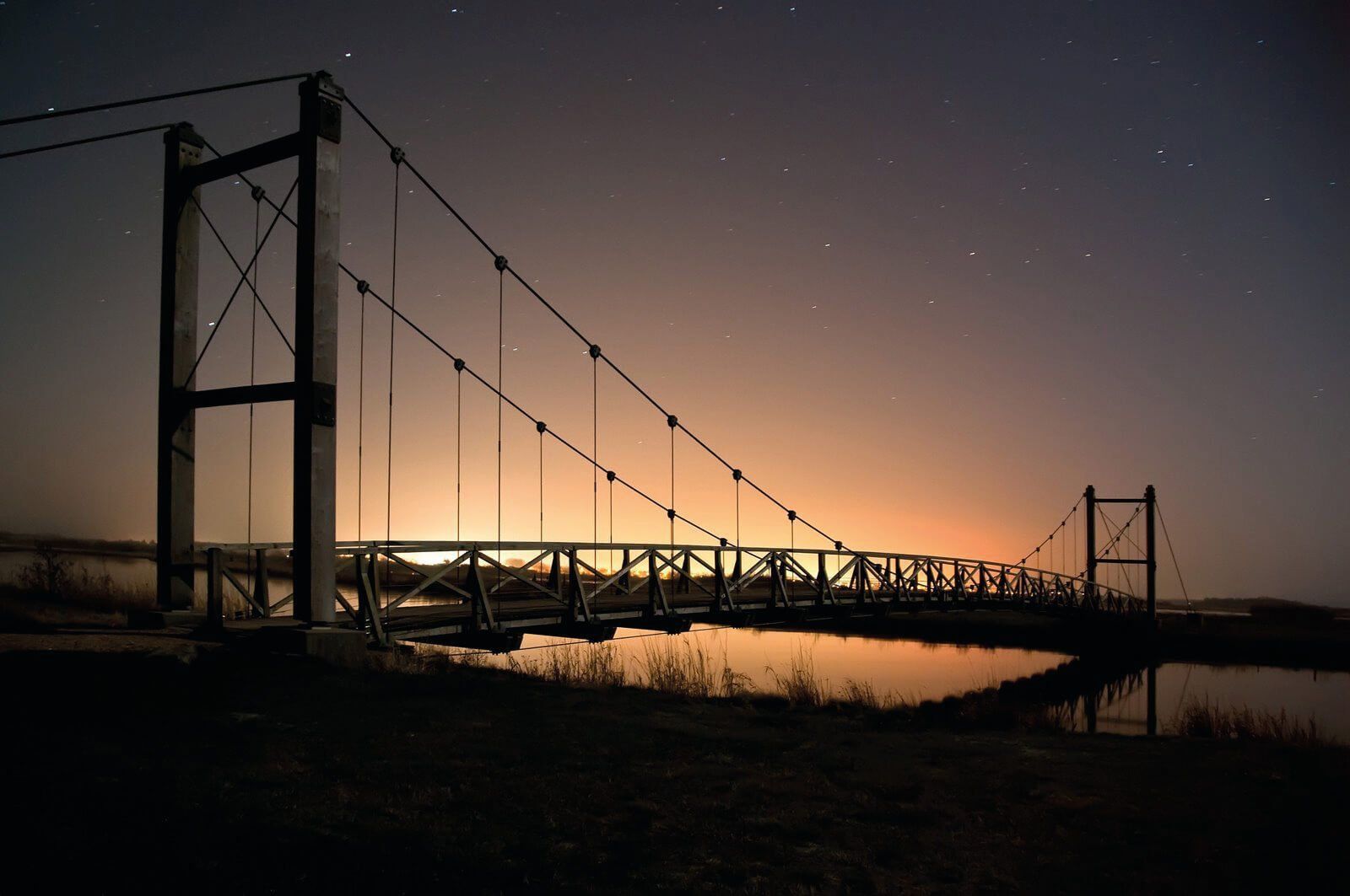 En hængebro over en vandmasse om natten