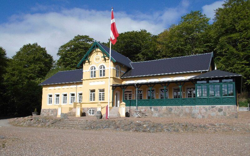 En gul bygning med et rødt og hvidt flag ovenpå