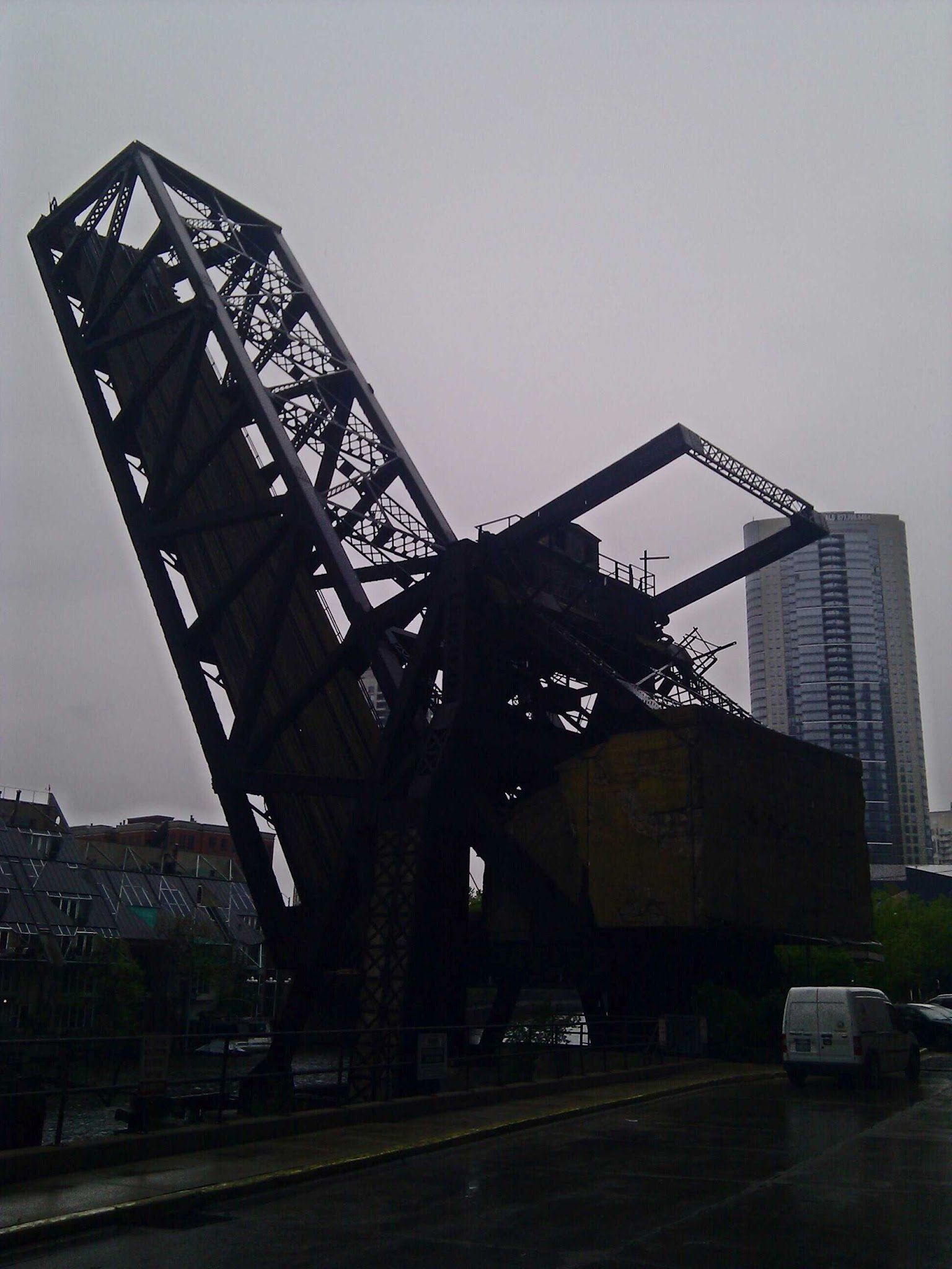 A silhouette of a bridge with a building in the background