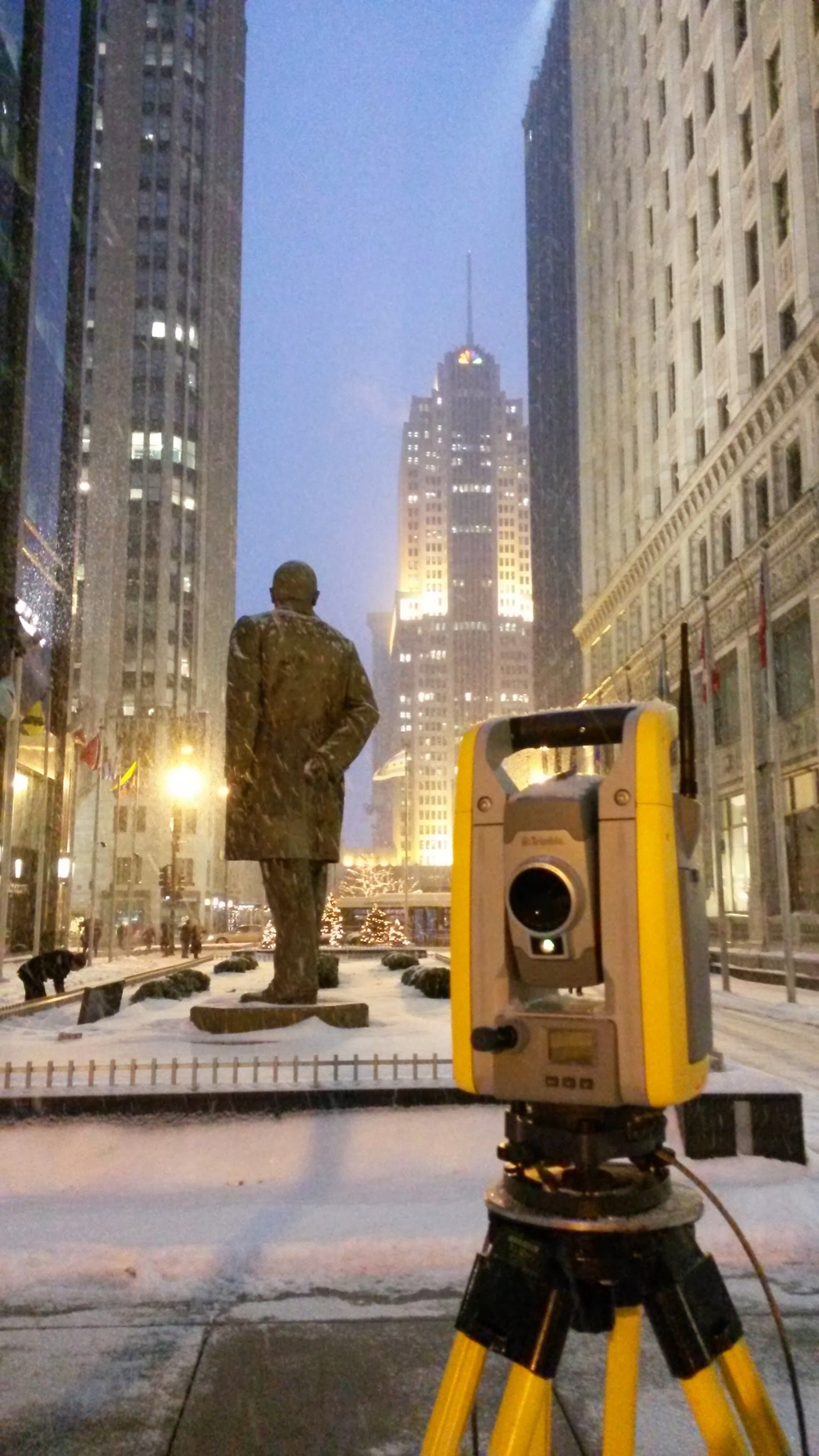 A statue of a man is behind a yellow device