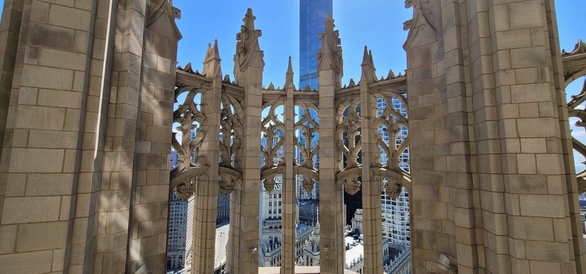 A very tall building is behind a stone fence.