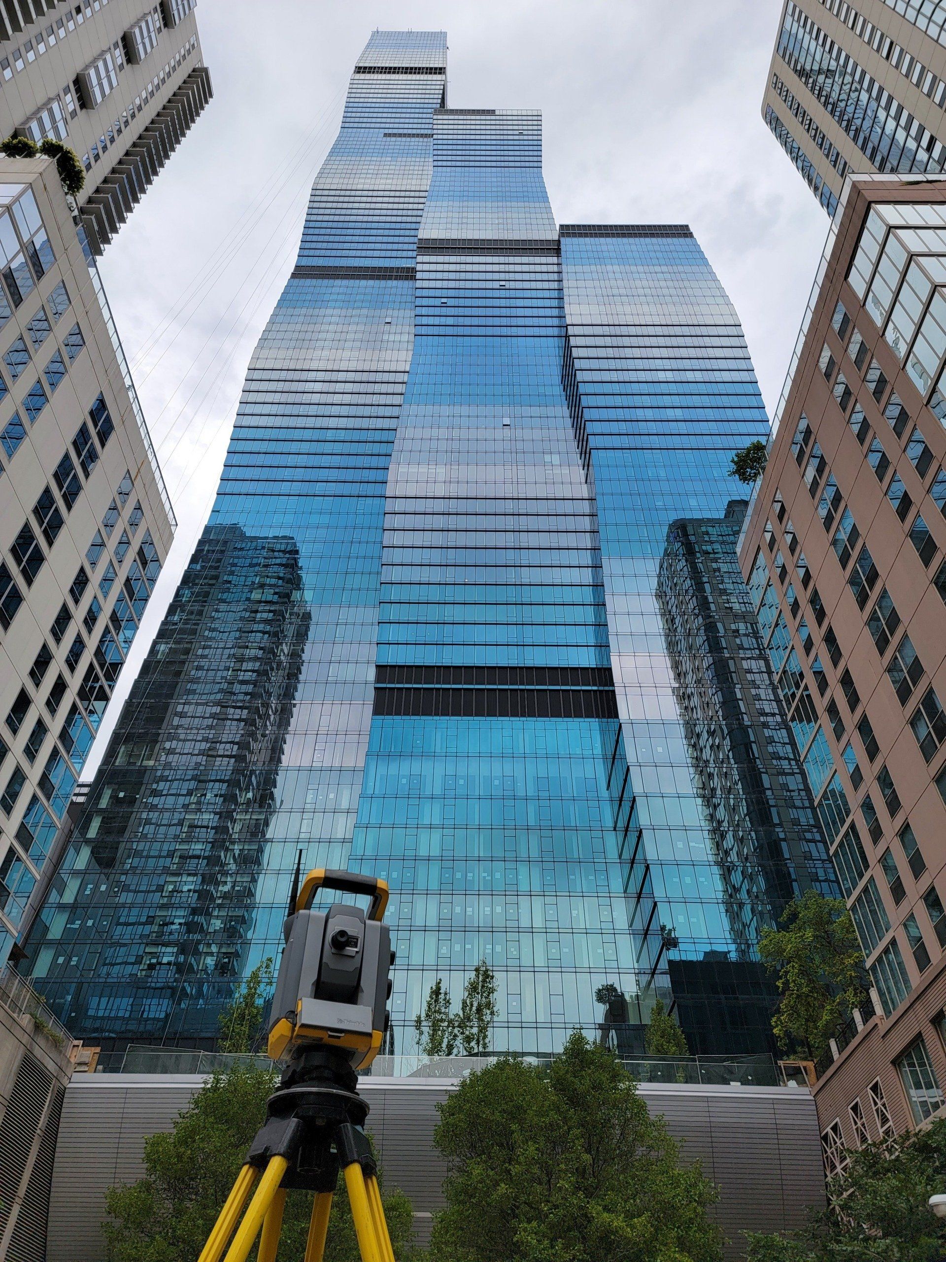 A tripod is sitting in front of a tall building.