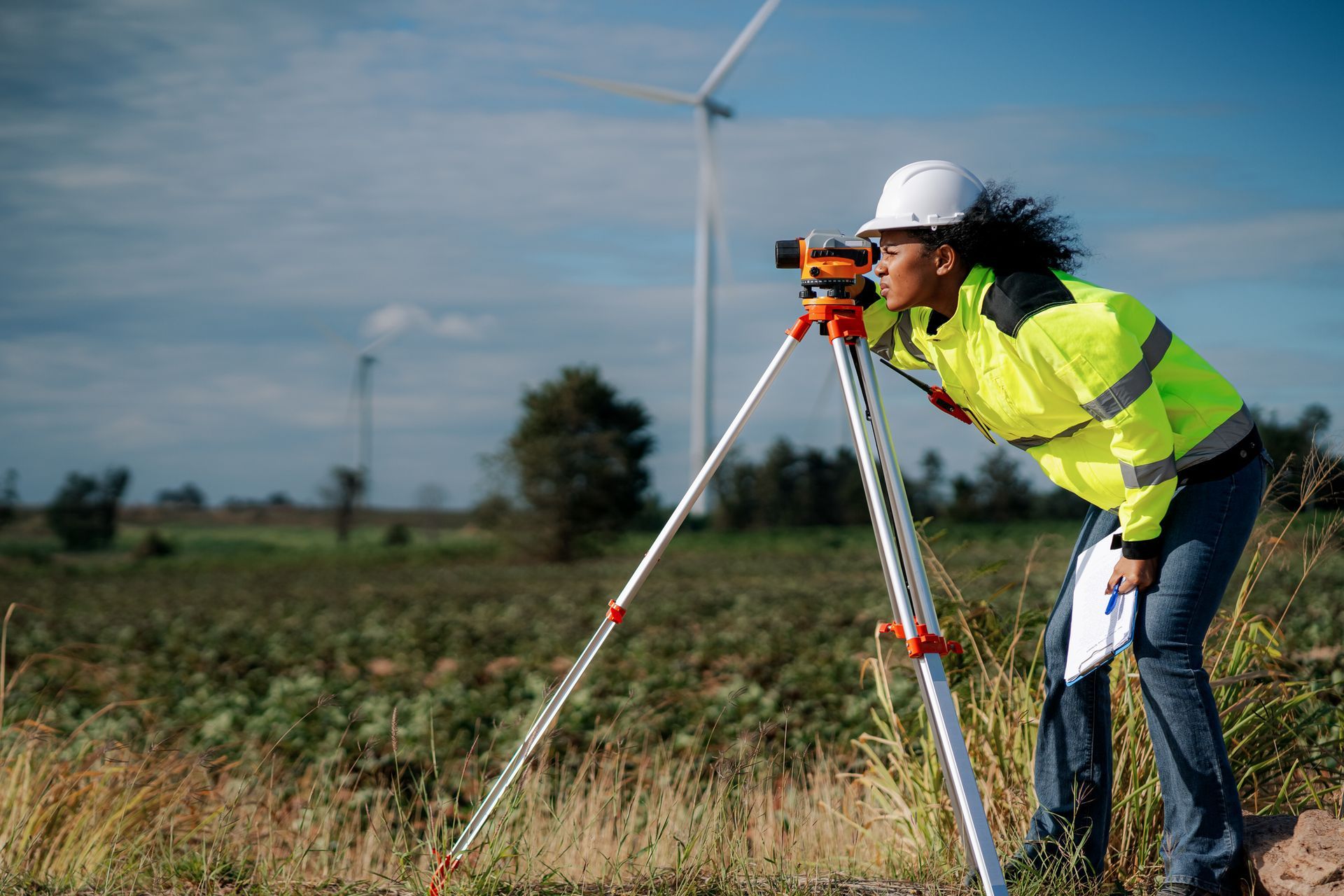 A woman is looking through a survey camera.