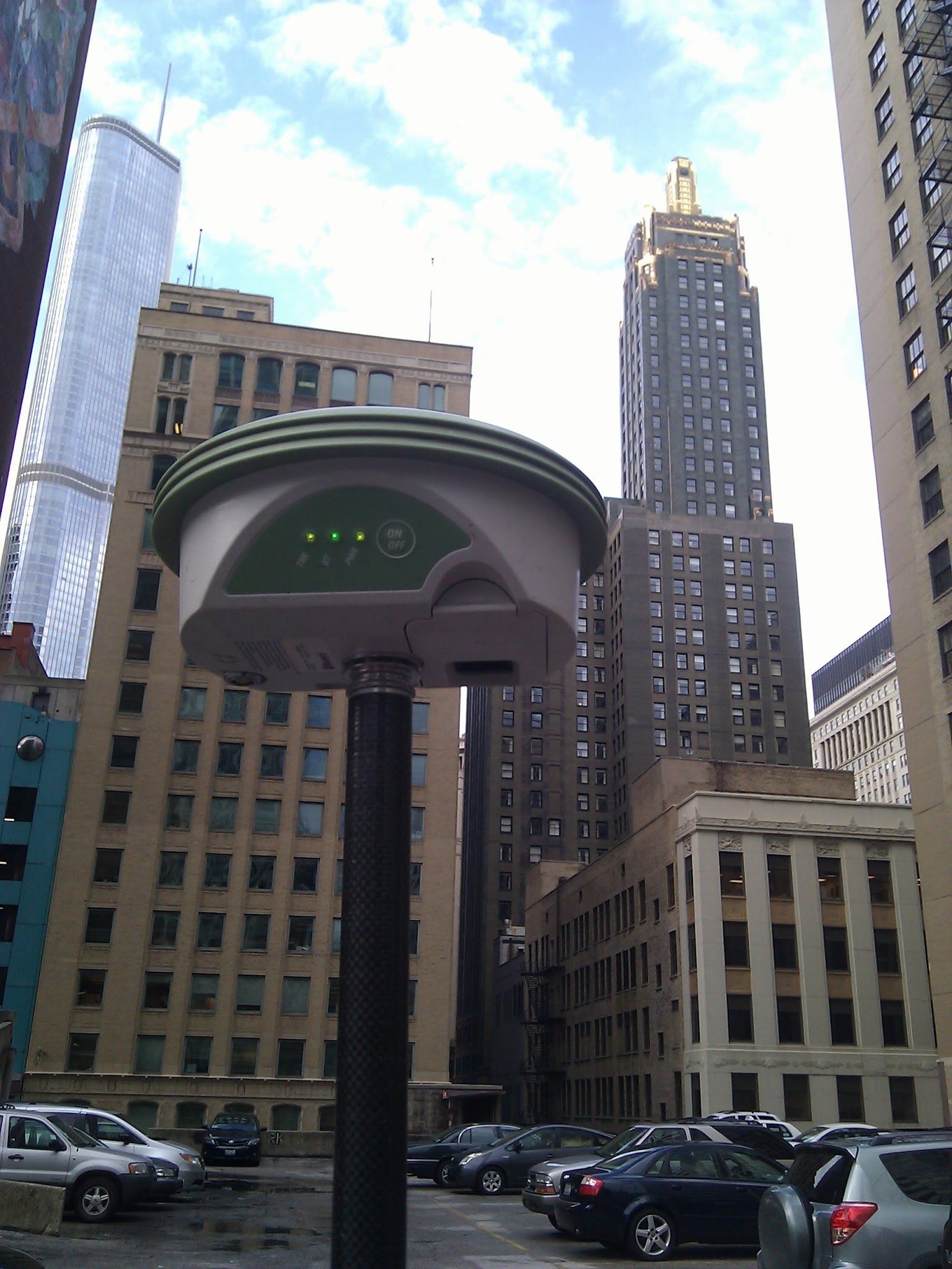 A street light in a parking lot with a tall building in the background