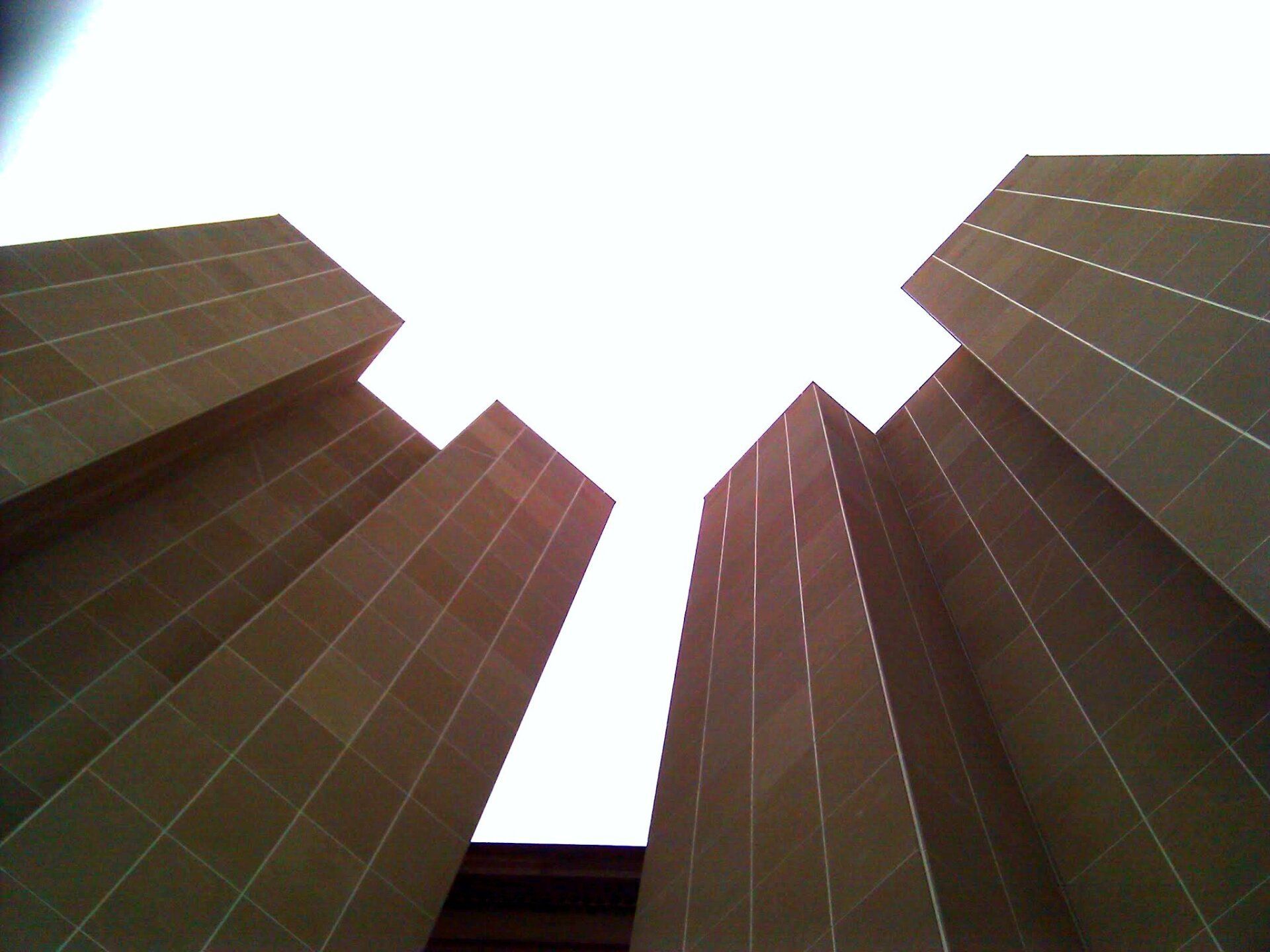 Looking up at a tall building with a white sky in the background