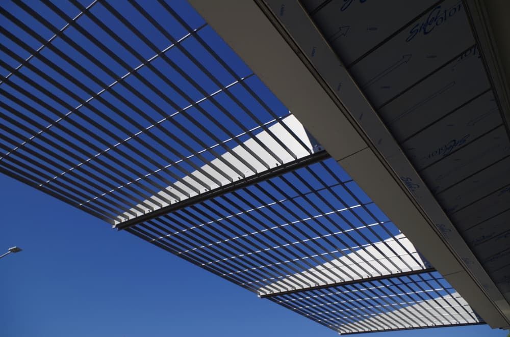 Geometric Metal Slats Create a Grid Pattern Against a Clear Blue Sky, Casting Shadows on the Structure