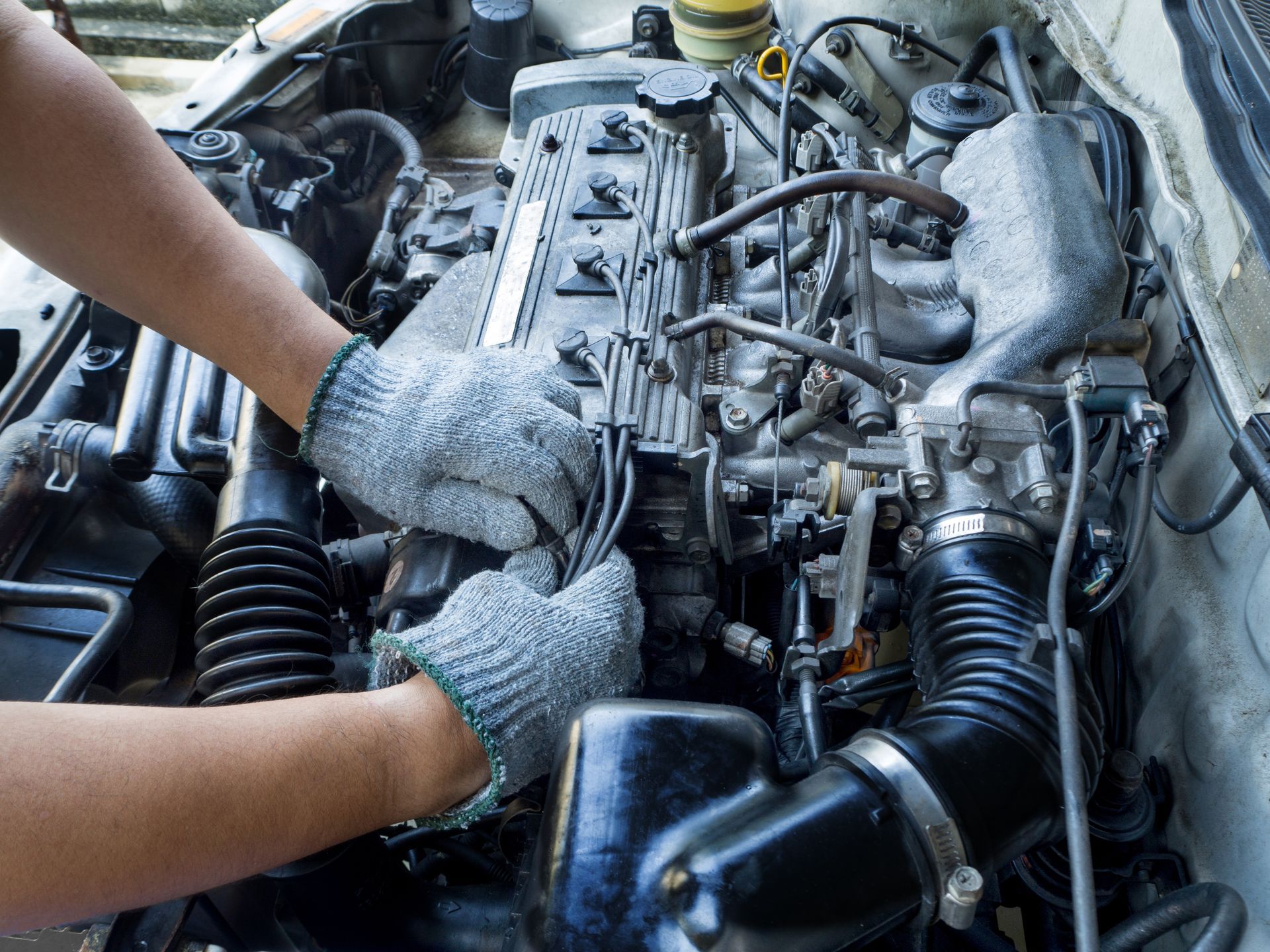 Mechanic’s Gloved Hands Working on an Open Car Engine in a Workshop — Supa Auto Services In Bundaberg, North