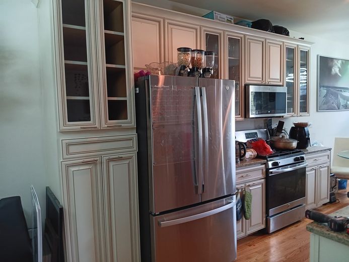 Kitchen with a stainless steel refrigerator, cabinets, and an oven.