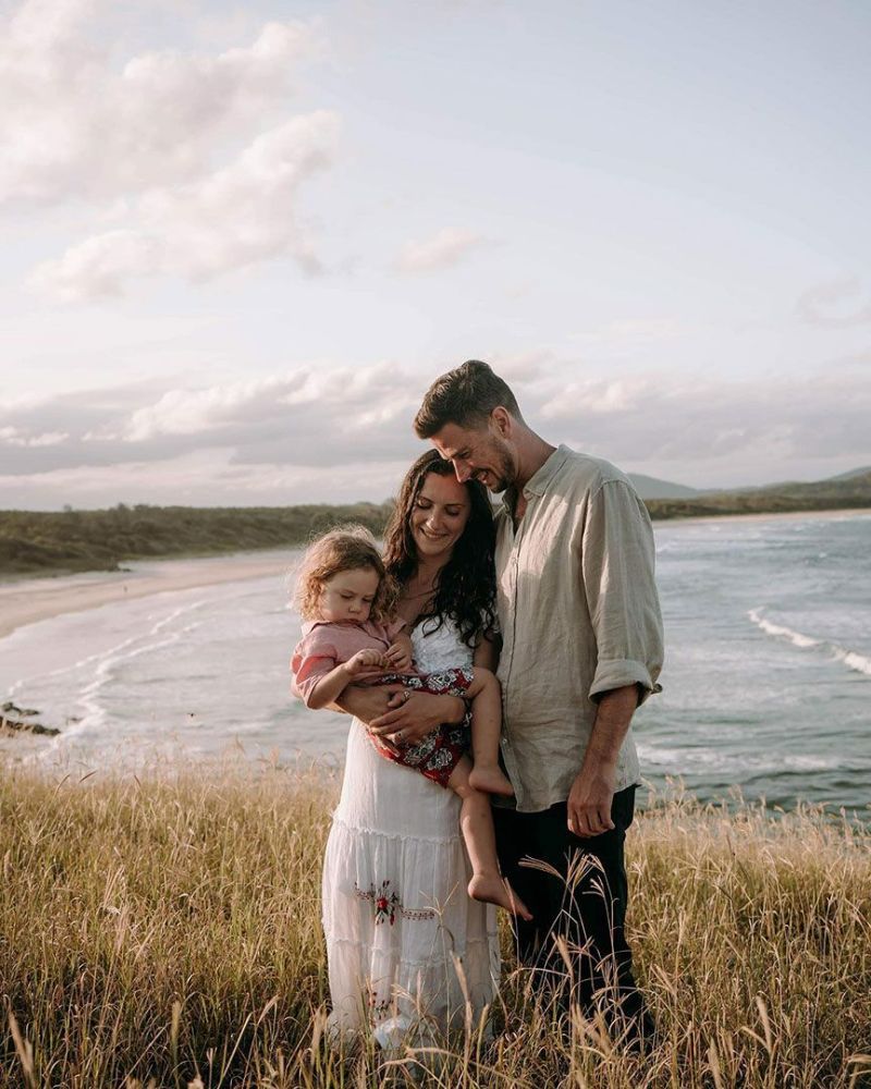 A Family Is Standing in A Field Near the Ocean — Seed + Salt Photography In Coffs Harbour, NSW
