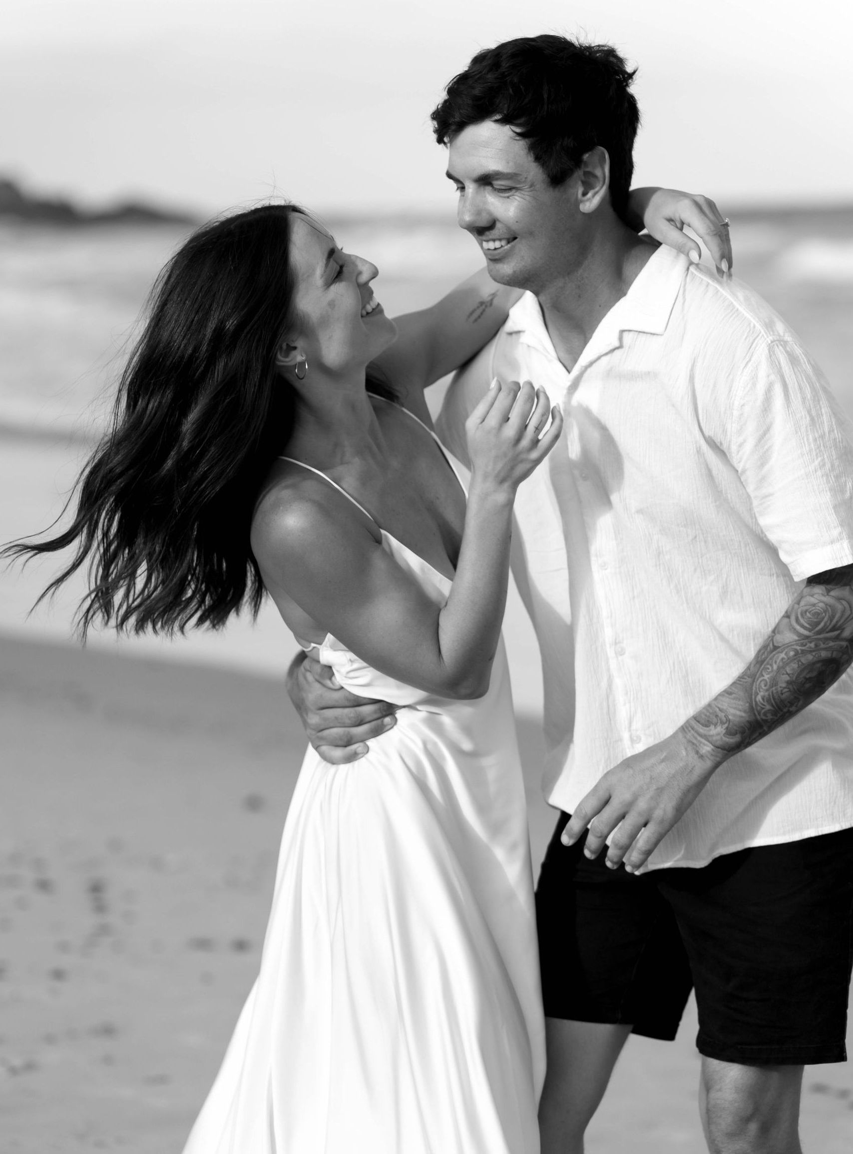 Bride and groom holding eacheother on the beach.  - Seed + Salt Photography In Smithtown, NSW