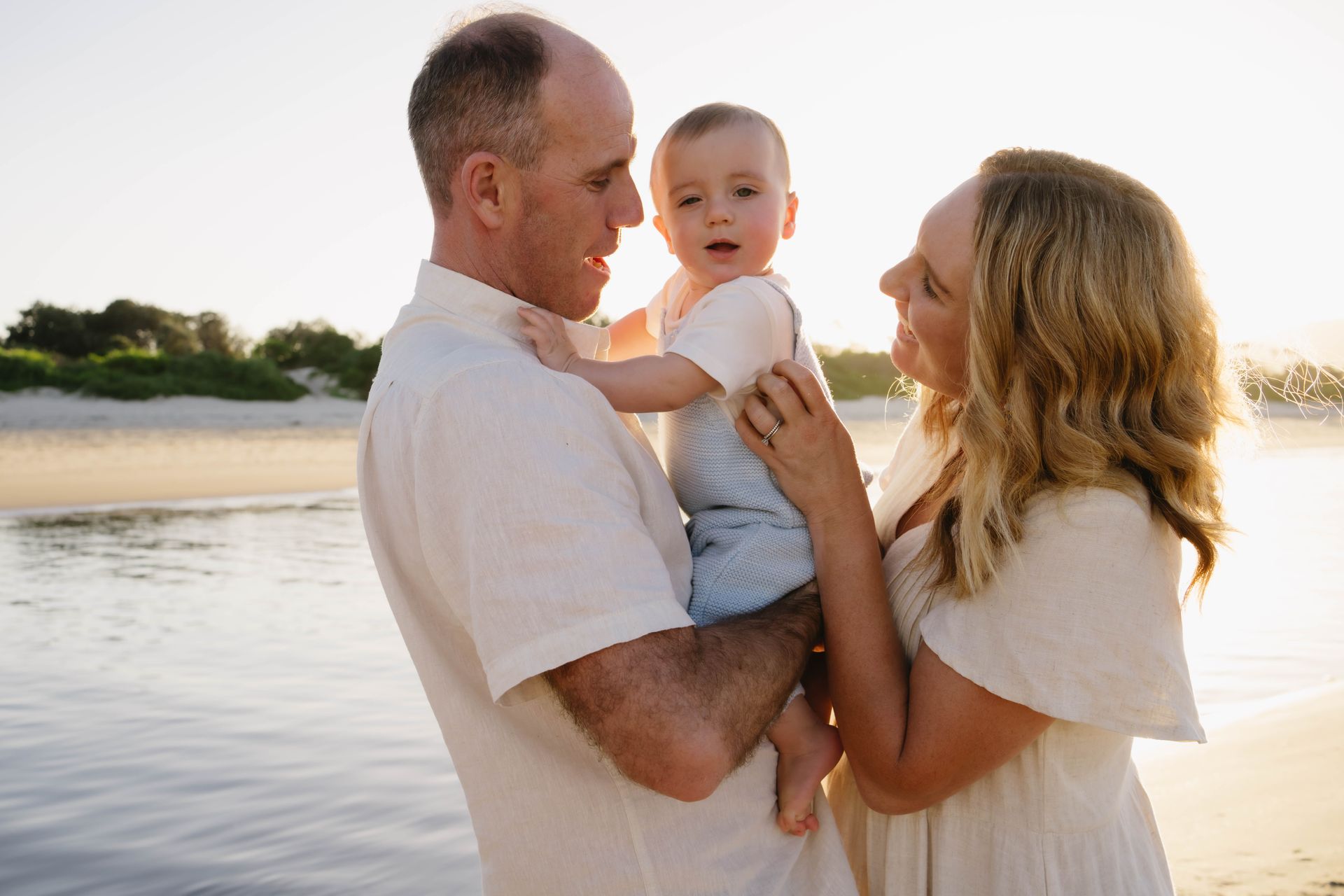 A Man and A Woman Are on the Ground Looking At a Child — Seed + Salt Photography In Smithtown, NSW