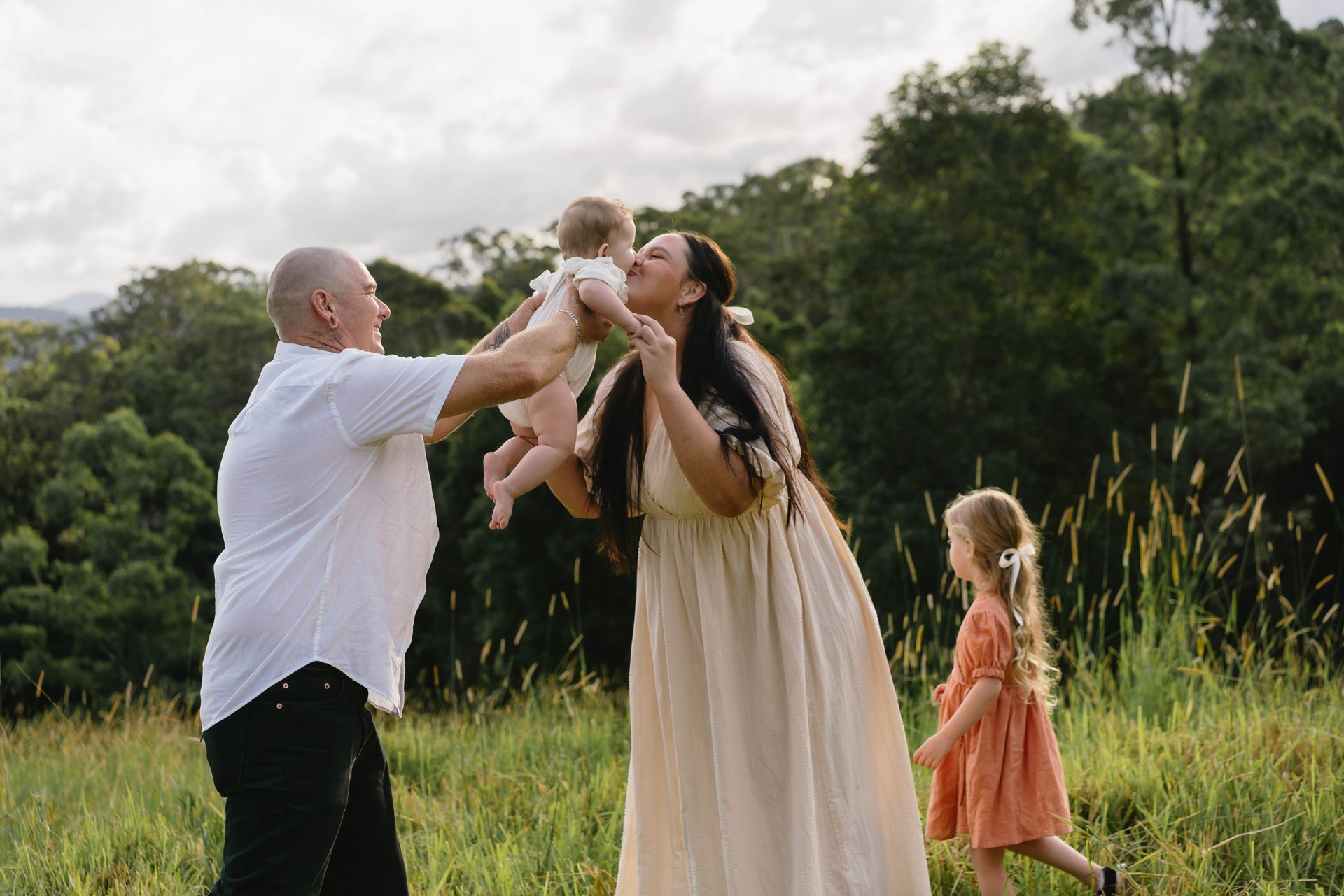 A Woman is holding A Little Girl in A Field — Seed + Salt Photography In Smithtown, NSW