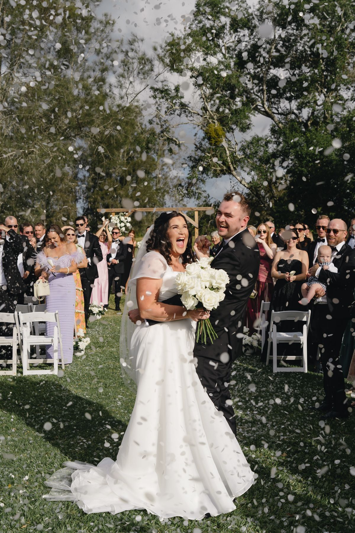 A Black and White Photo of A Bride and Groom With Sunglasses on Walking Through 2 Lines of People Holing Sparklers — Seed + Salt Photography In Smithtown, NSW