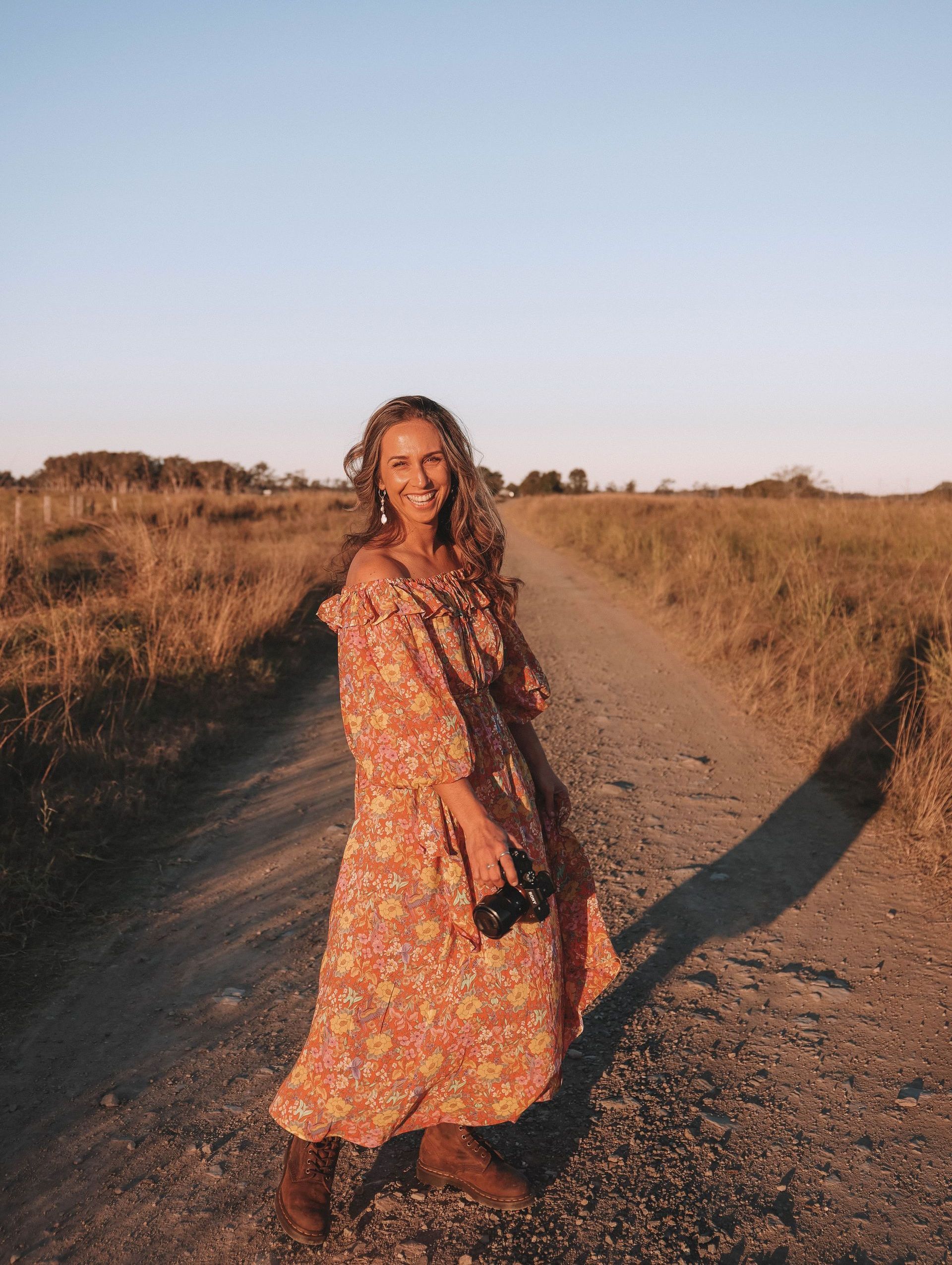 A woman standing with a camera in her hand