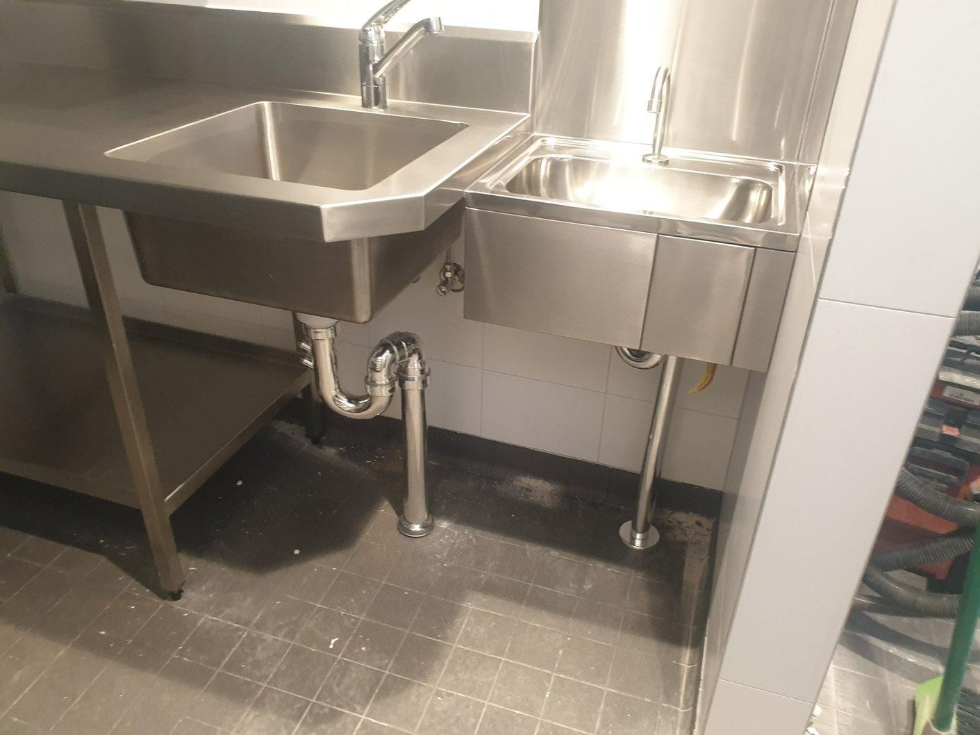 Two Stainless Steel Sinks Are Sitting Next to Each Other in A Kitchen — Gillespie Plumbing in Grafton, NSW