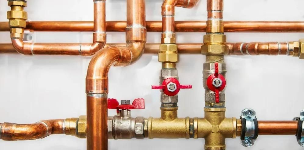 A Close up Of Copper Pipes and Valves on A Wall — Gillespie Plumbing in Grafton, NSW