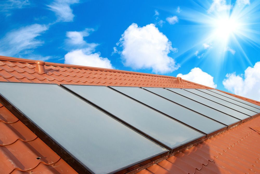 A Row of Solar Panels on A Roof with The Sun Shining Through Them — Gillespie Plumbing in Grafton, NSW