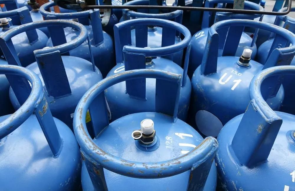 A Bunch of Blue Gas Cylinders Are Stacked on Top of Each Other — Gillespie Plumbing in Grafton, NSW