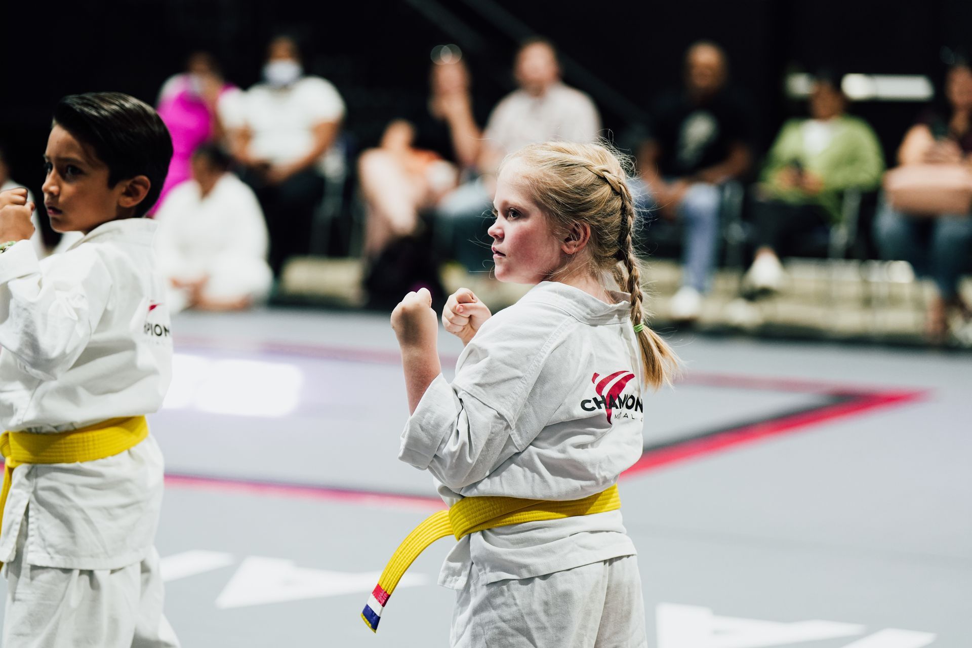 Person tying a brown karate belt around a white gi.
