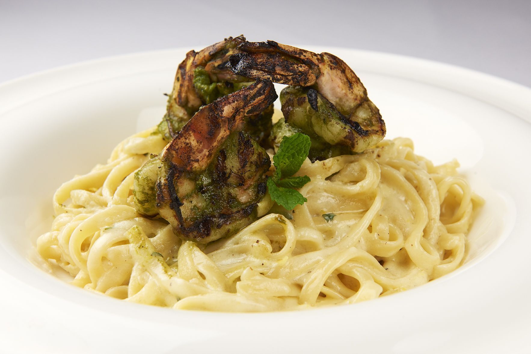 A close up of a plate of pasta with shrimp on top