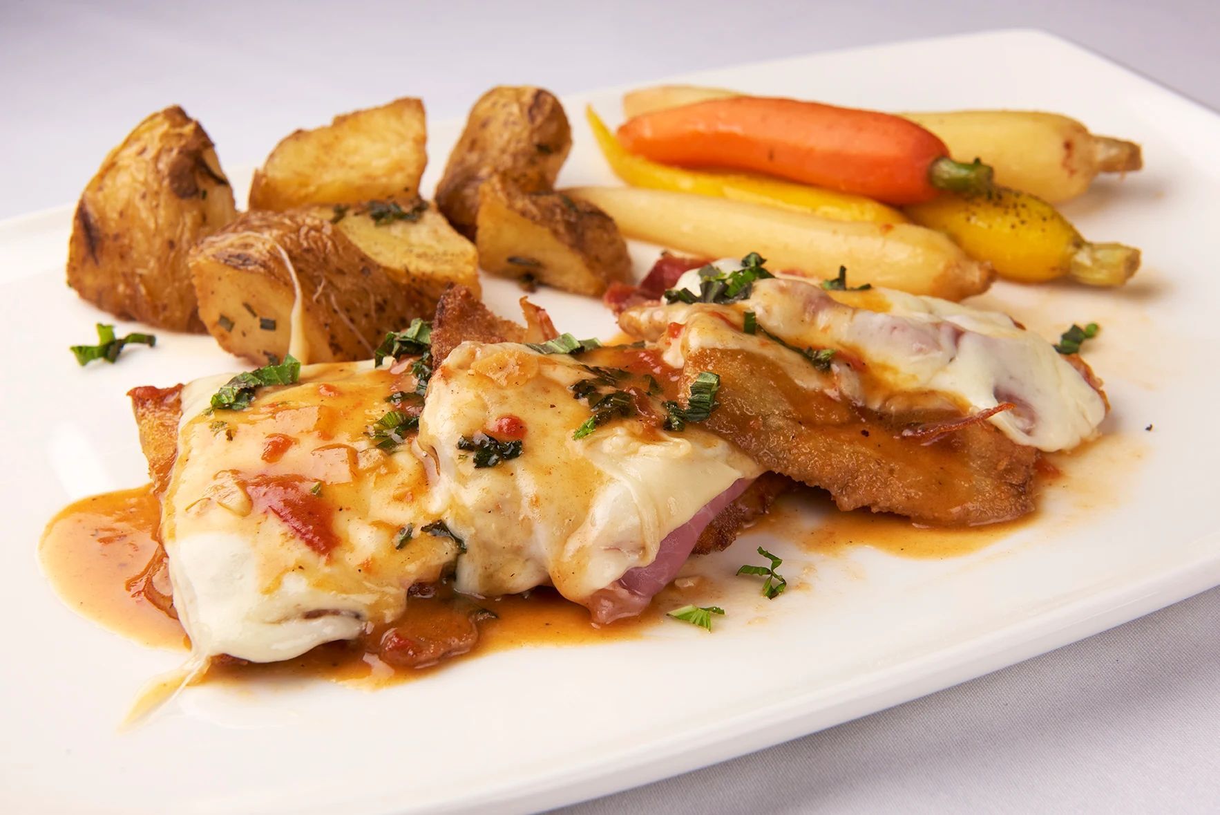 A white plate topped with meat and vegetables on a table