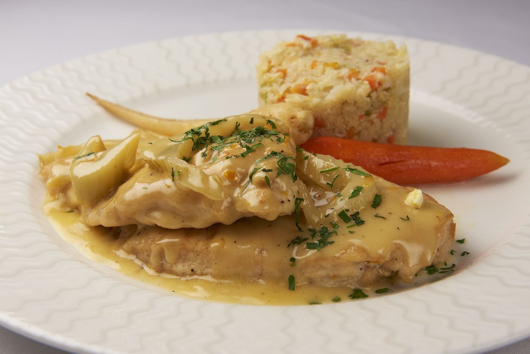 A white plate topped with chicken , carrots and rice.