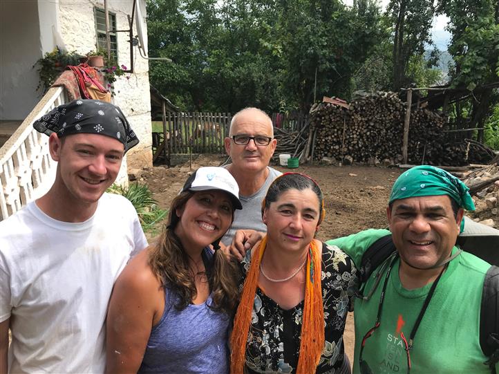 A group of people posing for a picture in front of a house.