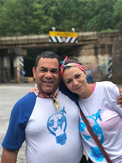 A man and a woman are posing for a picture in front of a bridge