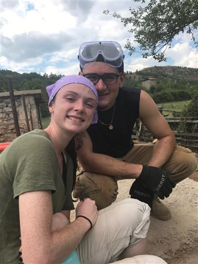 A man and a woman are posing for a picture and the man is wearing goggles