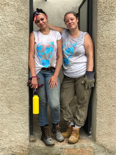 Two women are standing next to each other in a doorway.