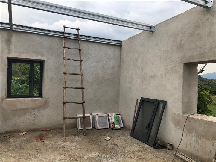 A ladder is hanging from the ceiling of a building under construction.