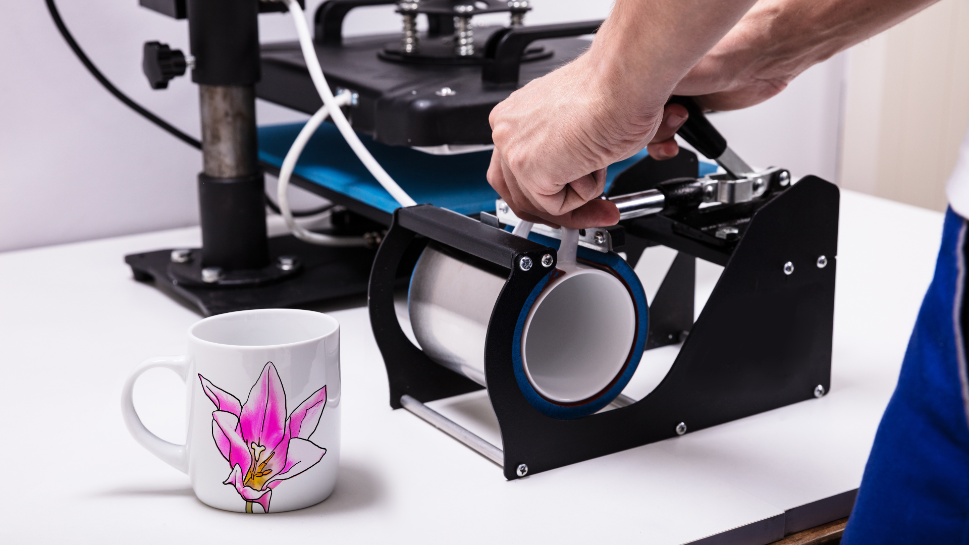 A person is using a machine to make a mug.