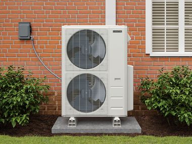 White outdoor HVAC unit with two fans beside a red brick wall and window shutters.